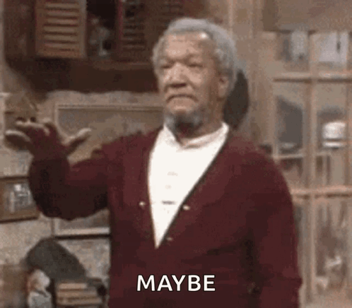 A Man With A Beard Is Wearing A Red Sweater And Making A Funny Face While Standing In A Room . GIF