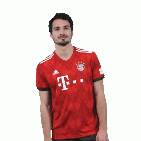 A Man With A Beard Is Wearing A Red T-Mobile Jersey And Making A Funny Face . GIF