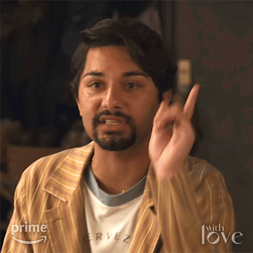 A Man With A Beard Is Wearing A Striped Jacket And A T-Shirt That Says Rye On It . GIF