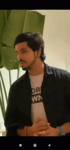 a man with a beard is wearing a t-shirt that says " or " on it .