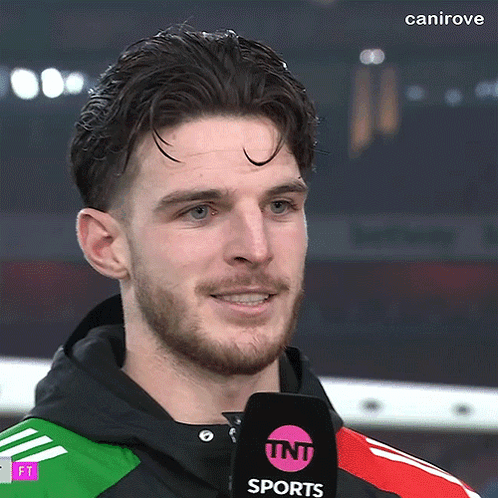 A Man With A Beard Is Wearing A Tnt Sports Microphone GIF