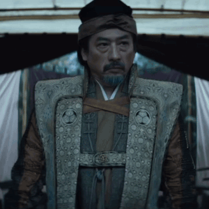 A Man With A Beard Is Wearing A Vest With A Circle On The Front GIF