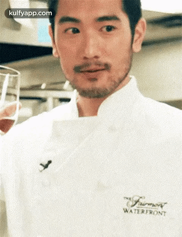 A Man With A Beard Is Wearing A White Chef 'S Coat And Holding A Glass . GIF