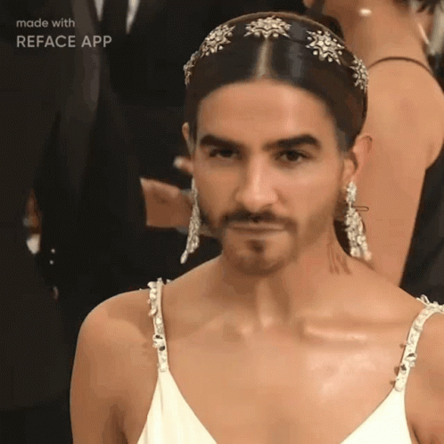 A Man With A Beard Is Wearing A White Dress And Earrings Made By Reface App GIF
