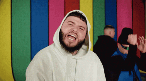 A Man With A Beard Is Wearing A White Hoodie That Says ' Supreme ' On It GIF