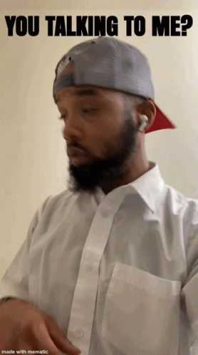 A Man With A Beard Is Wearing A White Shirt And A Gray Hat With The Words You Talking To Me Above Him GIF