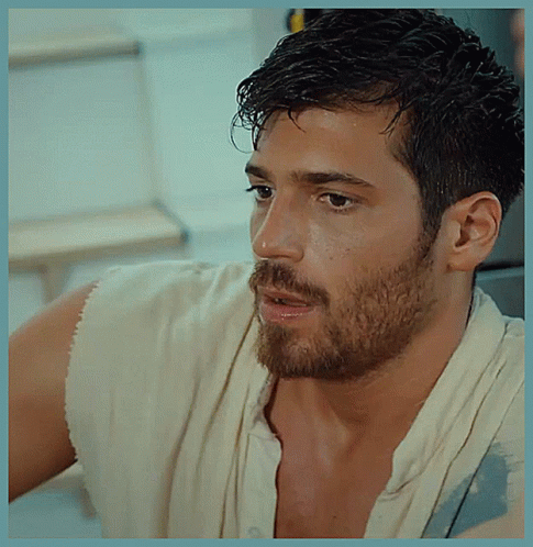 A Man With A Beard Is Wearing A White Shirt And A White Towel Around His Neck GIF