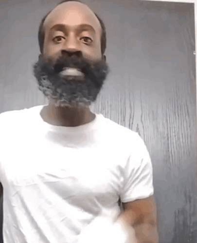 a man with a beard is wearing a white shirt and smiling