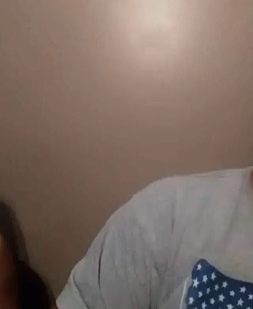 A Man With A Beard Is Wearing A White Shirt With A Blue And White American Flag On It . GIF