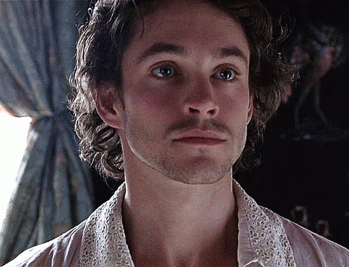 A Man With A Beard Is Wearing A White Shirt With A Lace Collar GIF
