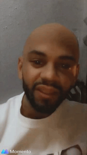 A Man With A Beard Is Wearing A White Shirt With The Word Momento On It GIF