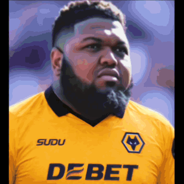 a man with a beard is wearing a yellow shirt that says debet on it
