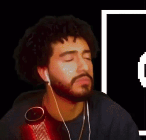 A Man With A Beard Is Wearing Ear Buds And A Microphone GIF