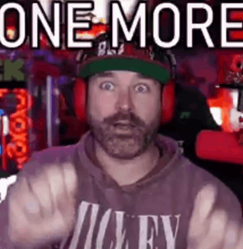 A Man With A Beard Is Wearing Headphones And A Hat And Giving The Middle Finger . GIF