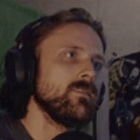 A Man With A Beard Is Wearing Headphones And A Headset . GIF