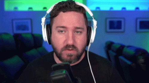 A Man With A Beard Is Wearing Headphones And A Microphone GIF