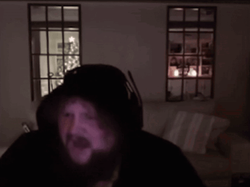 A Man With A Beard Is Wearing Headphones And Looking At The Camera GIF