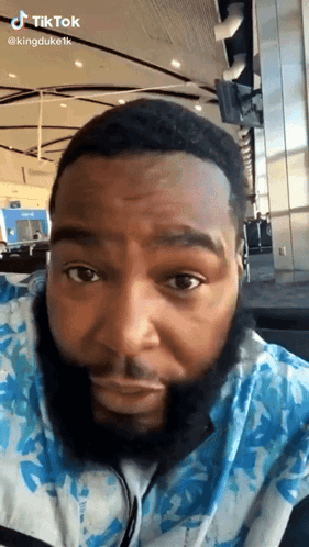 A Man With A Beard Is Wearing Headphones And Looking At The Camera GIF