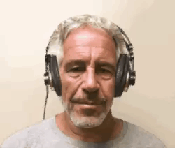 A Man With A Beard Is Wearing Headphones And Making A Funny Face . GIF
