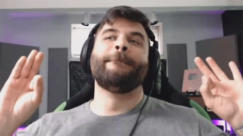 A Man With A Beard Is Wearing Headphones And Making An Ok Sign GIF