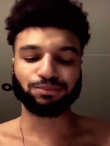 A Man With A Beard Is Without A Shirt And Is Looking Down . GIF