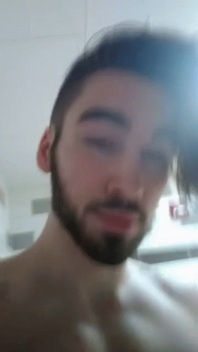 A Man With A Beard Looks At The Camera GIF
