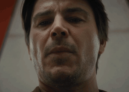 A Man With A Beard Looks At The Camera With A Serious Look On His Face GIF