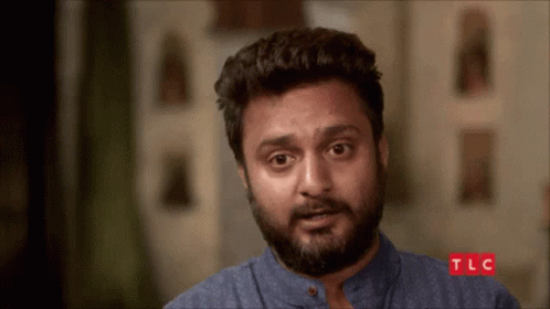 A Man With A Beard Looks At The Camera With Tlc Written On The Bottom GIF