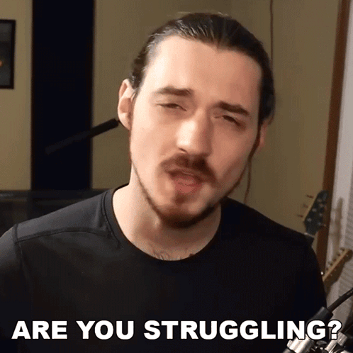 A Man With A Beard Says " Are You Struggling " In Front Of A Microphone GIF