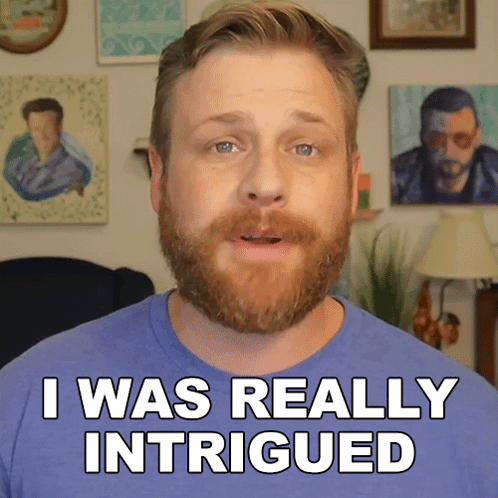 A Man With A Beard Says " I Was Really Intrigued " In Front Of Some Paintings GIF