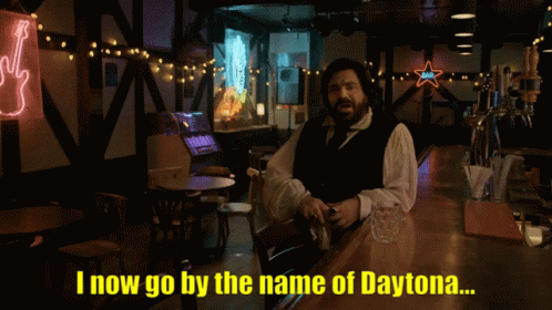 A Man With A Beard Says Jackie Daytona In A Dark Room GIF