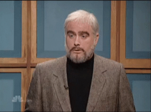 A Man With A Beard Says " Moo " While Standing In Front Of A Wooden Wall GIF