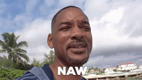 A Man With A Beard Says Naw In Front Of A Beach GIF