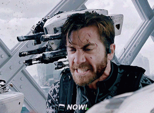 A Man With A Beard Says Now In Front Of A Robot GIF