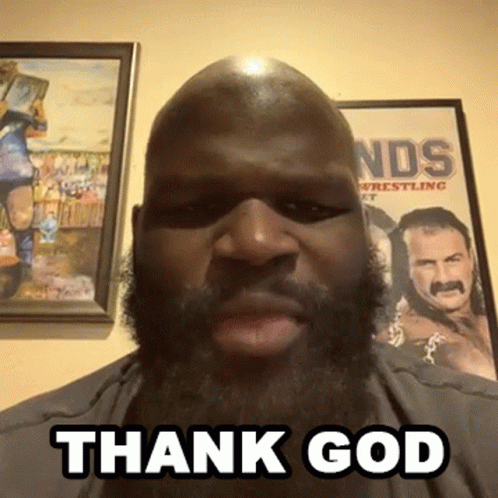 A Man With A Beard Says " Thank God " In Front Of A Wrestling Poster GIF
