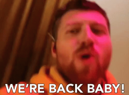 a man with a beard says " we 're back baby " in front of a pink background