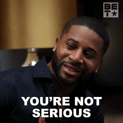 a man with a beard says you 're not serious in front of a lamp