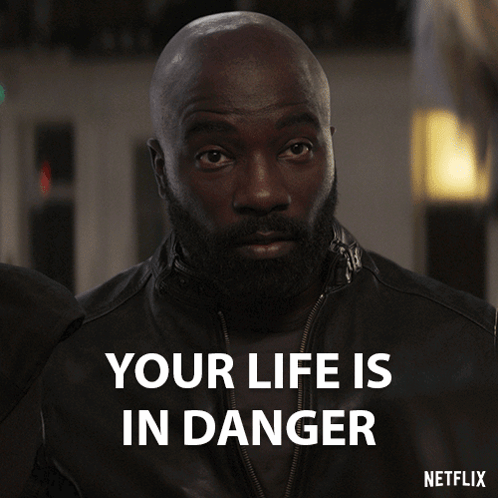 A Man With A Beard Says Your Life Is In Danger On A Netflix Poster GIF