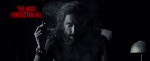 A Man With A Beard Smoking A Cigarette With The Words Yeh Naya Hindustan Hai In Red Letters GIF