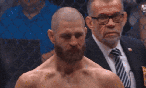 A Man With A Beard Stands In Front Of A Man In A Suit GIF