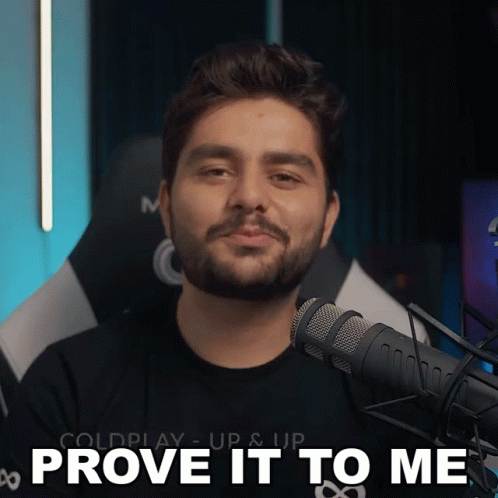 A Man With A Beard Stands In Front Of A Microphone And Says " Prove It To Me " GIF