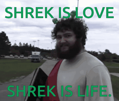 A Man With A Beard Stands In Front Of A Sign That Says Shrek Is Love And Shrek Is Life GIF