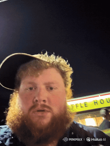 A Man With A Beard Stands In Front Of A Yellow Sign That Says Waffle House GIF