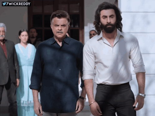A Man With A Beard Stands Next To Another Man GIF
