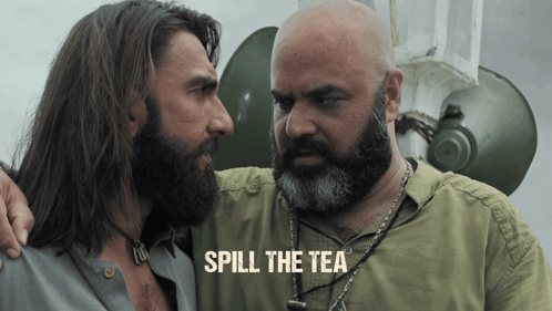 A Man With A Beard Stands Next To Another Man With The Words Spill The Tea On The Bottom GIF