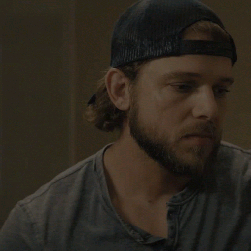 A Man With A Beard Wearing A Baseball Cap Says I 'Ll Be Back Soon GIF