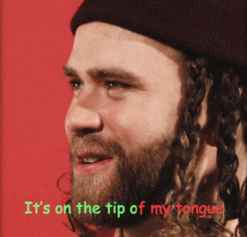 A Man With A Beard Wearing A Beanie Has The Words It 'S On The Tip Of My Tongue Above Him GIF