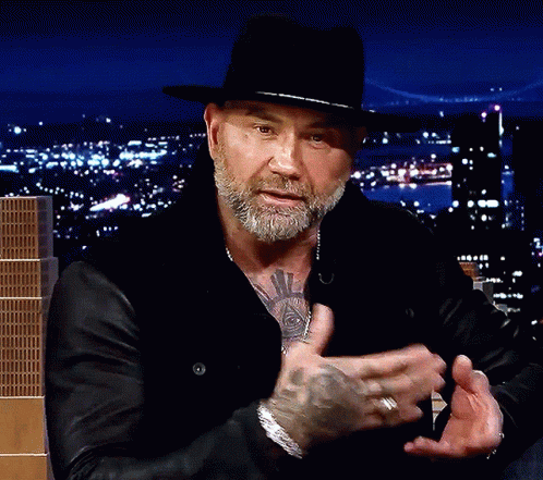 A Man With A Beard Wearing A Black Hat And A Black Jacket GIF