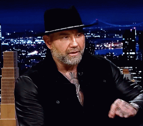 A Man With A Beard Wearing A Black Hat And A Leather Jacket GIF