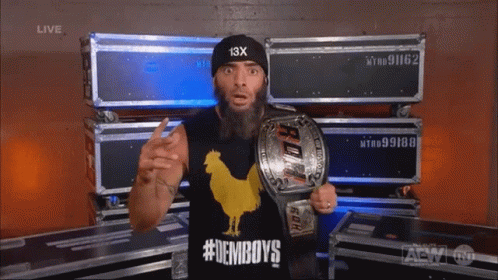 A Man With A Beard Wearing A Black Hat With 13X On It GIF